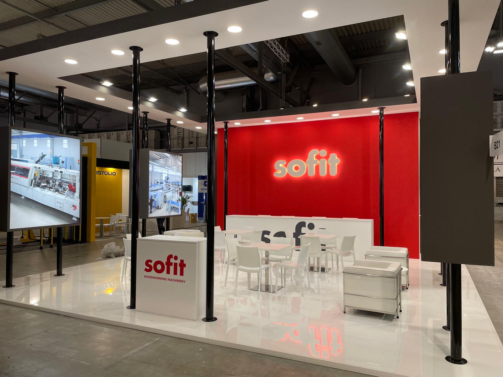 Stand SOFIT con parete rossa, pavimento in resina e area relax