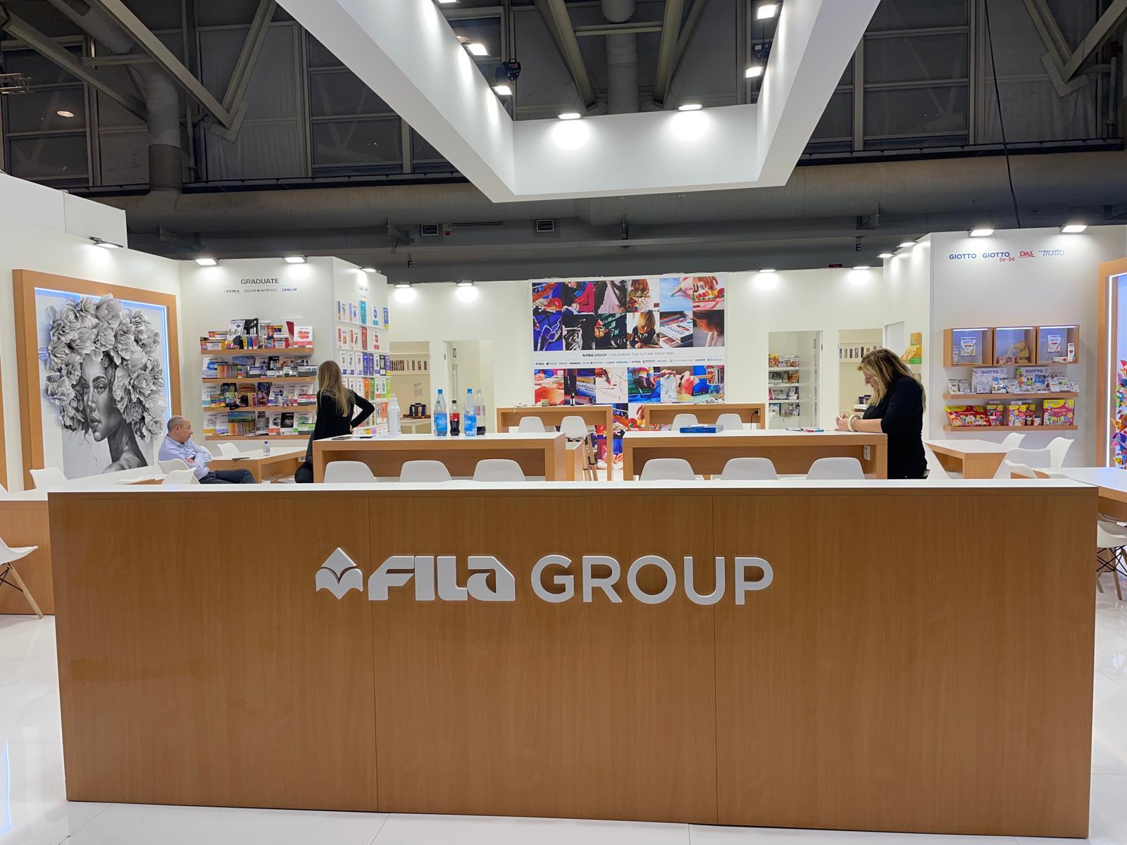 Stand FILA Group con bancone in legno e scaffali di prodotti per l'arte