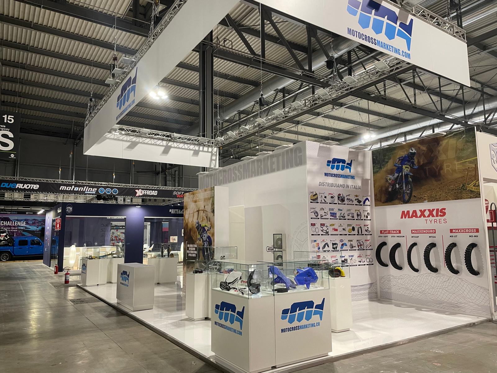 Stand Motocross Marketing con teche in vetro e pneumatici a muro