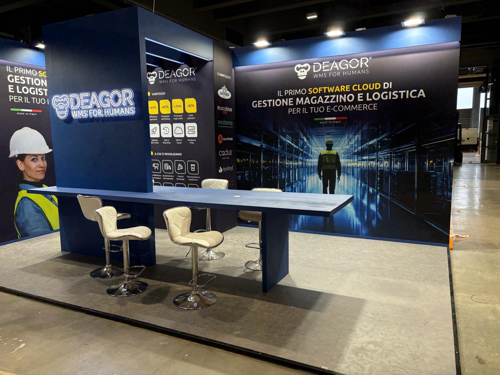 Stand DEAGOR WMS con parete grafica magazzino e bancone blu